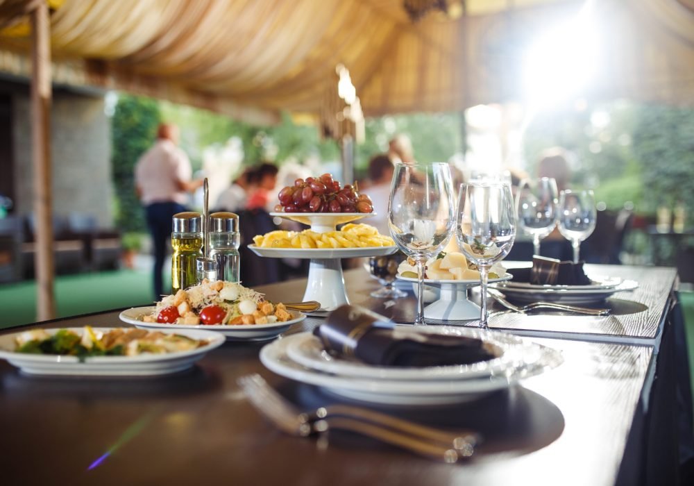 Sparkling glassware stands on long table prepared for wedding dinner.
